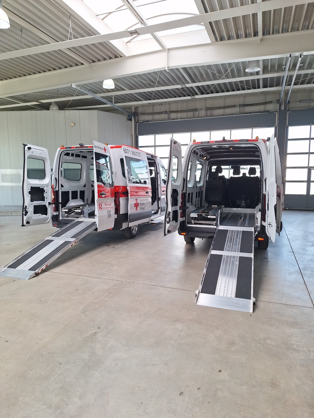 Zwei von WOLF umgebaute Rotkreuz-Transporter mit ausgeklappten Rollstuhlrampen in der Werkstatt in Backnang